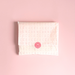 [main] Light Pink tissue paper featuring hot pink shapes of different boobs across the tissue paper to represent breastfeeding, featuring our signature Use Your Voice Smiley Face sticker in the center. 